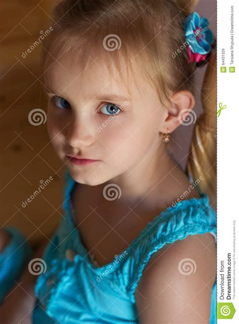 Portrait Of A Beautiful Sweet Little Girl In A Blue Dress With Blue