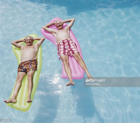 Two Senior Men Lying On Airbeds In A Swimming Pool Photo Getty Images