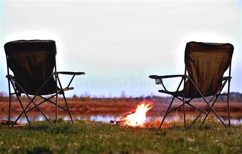 A Pair Of Tourist Chairs A Folding Chair A Bonfire On The River Bank