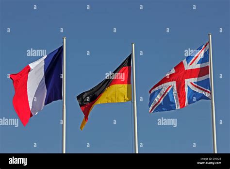 French German And British Flags Flying Against Blue Sky Stock Photo