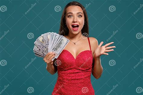 Brunette Girl With A Long Hair Wearing A Red Dress Is Posing Holding A Fan Of Hundred Dollar
