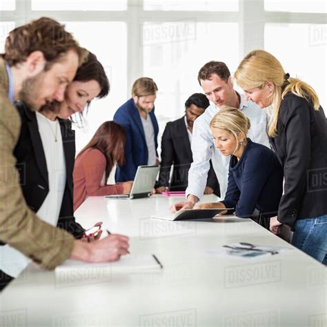 Group Of Business People Working Together At Desk In Office Stock