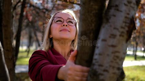 Cute Blonde Hugs A Tree In The Autumn City Park Beautiful Woman Gently