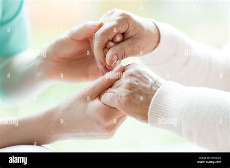 Photo With Close Up Of Caregiver And Patient Holding Hands Stock Photo