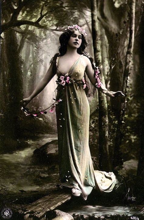 A Woman Standing In The Woods With Her Arms Outstretched And Flowers On Her Head Wearing A