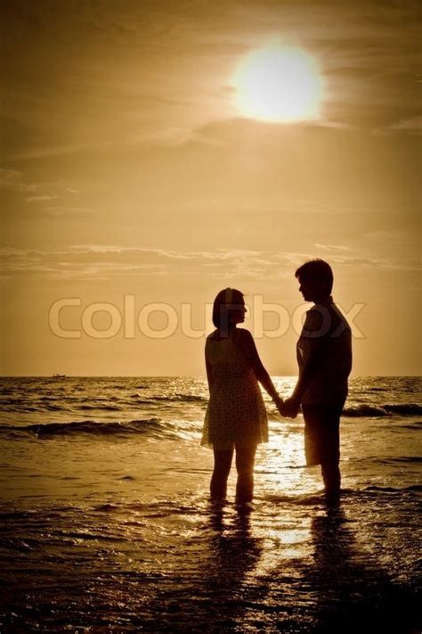 Romantic Scene Of Couples On The Beach With Sunset Stock Photo