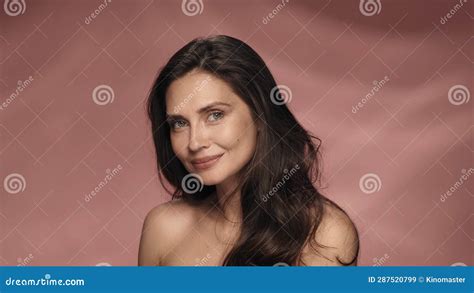 Portrait Of A Seminude Woman On A Pink Background Close Up Longhaired Brunette Woman With A