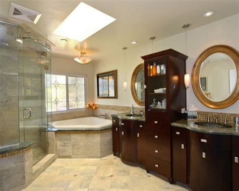 Luxurious bathroom features corner his and her showers clad in gray and white marble lined with a corner shower caddy flanking a freestanding tub and floor mount tub filler, placed dead center of the room, atop a mosaic marble grid tiled floor placed in front of french doors. Corner Tub | Houzz