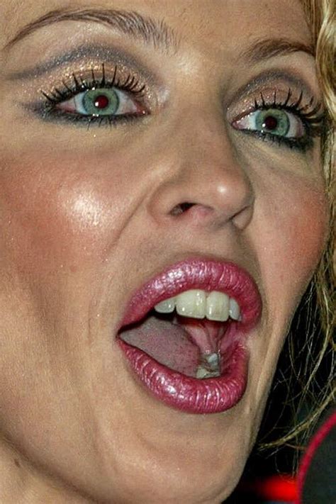 A Close Up Of A Woman With Her Mouth Open And Tongue Out To The Side