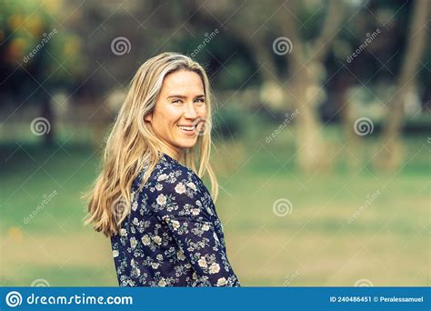 Woman In Her Thirties Turns Smiling At The Camera In A Flowery Shirt
