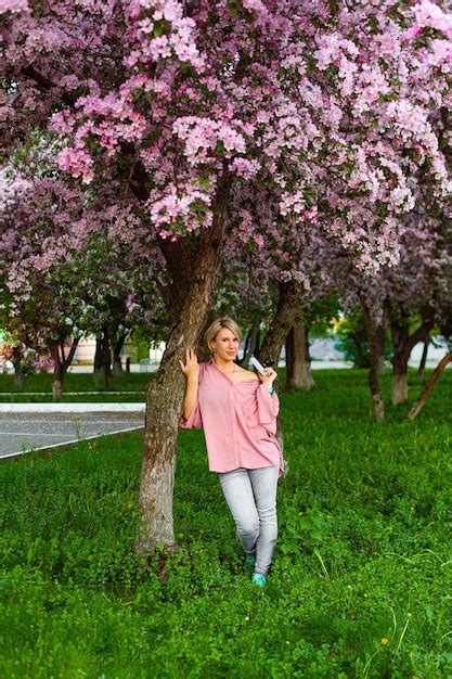 Premium Photo Beautiful Young Lady In The Garden Of Cherry Blossoms