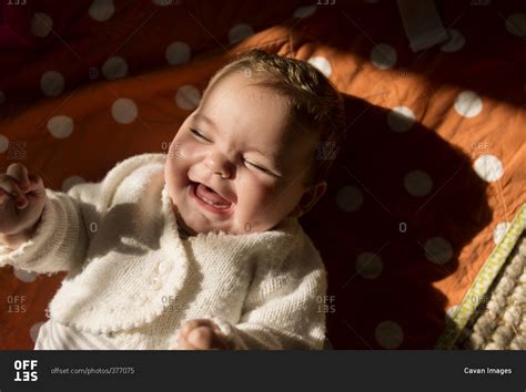 Overhead View Of Cheerful Baby Girl Lying On Bed Stock Photo Offset