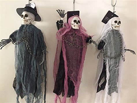 Three Halloween Decorations Hanging From Hooks On A Wall