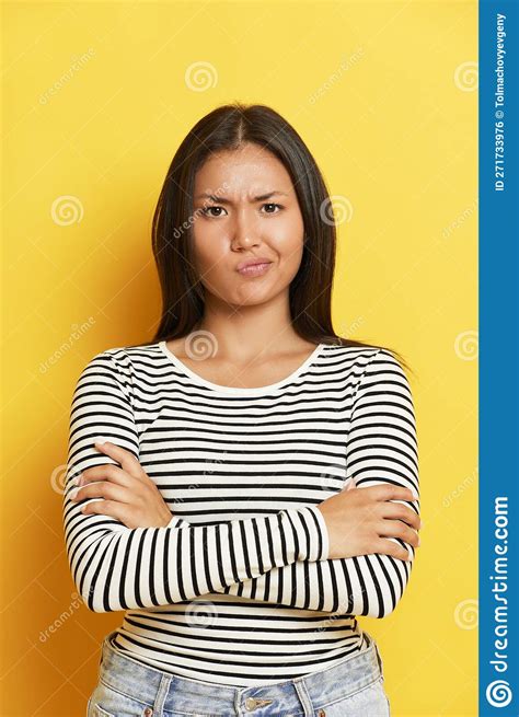 Portrait Of Pretty Unsatisfied Dark Haired Asian Woman Folded Arms