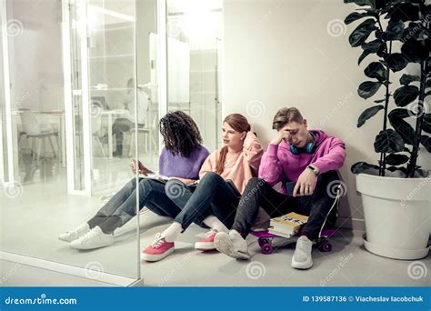 Three Students Sitting On The Floor Waiting For Their Turn To Answer
