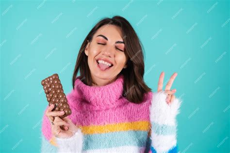 Free Photo A Young Woman In A Bright Multi Colored Sweater On Blue