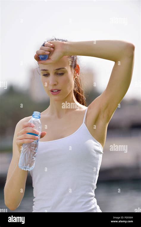 Young Beautiful Woman Drinking Water After Fitness Exercise Stock Photo