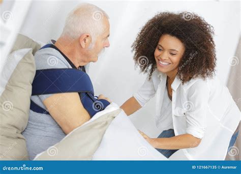 Smiling Female Assitant With Senior Man On Bed At Home Stock Image Image Of Household