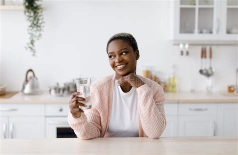 Smiling Glad Young Attractive Black Lady Holds Glass Of Clean Water