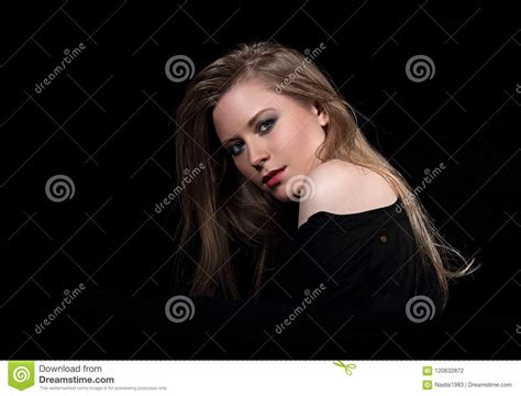 weibliches modell des sexy zaubers mit dem langen blonden haar das in schwarzem s aufwirft