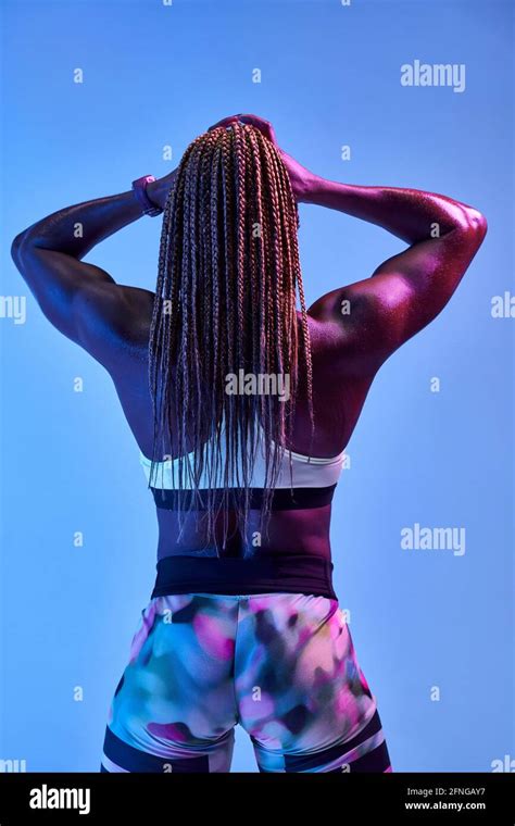 back view of anonymous muscular african american female athlete with sweaty body showing biceps
