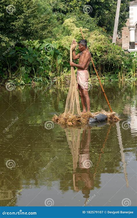 A Village Fisherman Is Throwing A Net For Fishing In A Pond Editorial