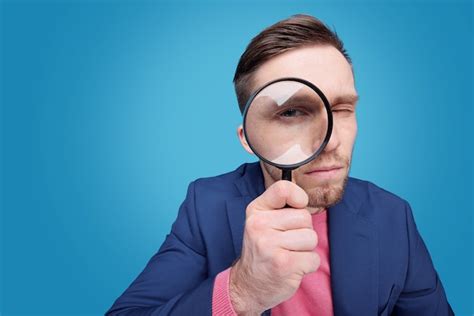 Premium Photo Serious Young Male Detective Holding Magnifying Glass