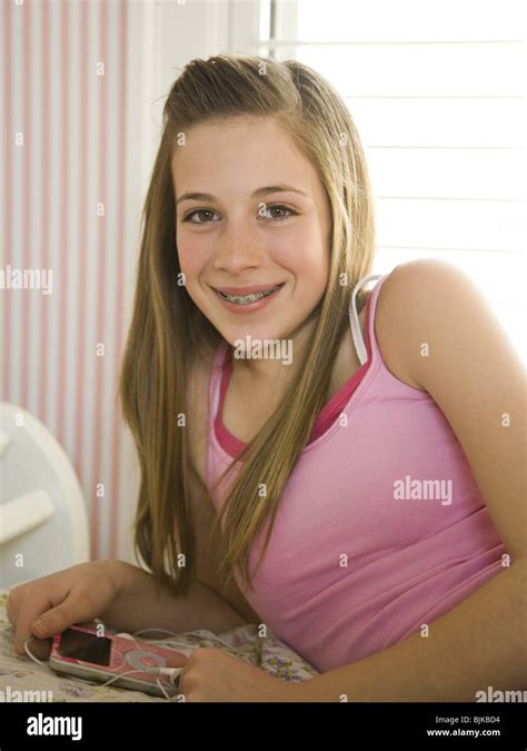 Mädchen Mit Zahnspange Auf Bett Mit Haarbürste Lächelnd Stockfotografie