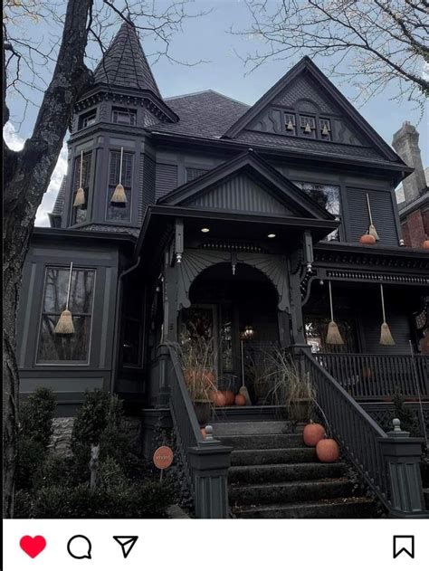 An Old Victorian House With Pumpkins On The Steps