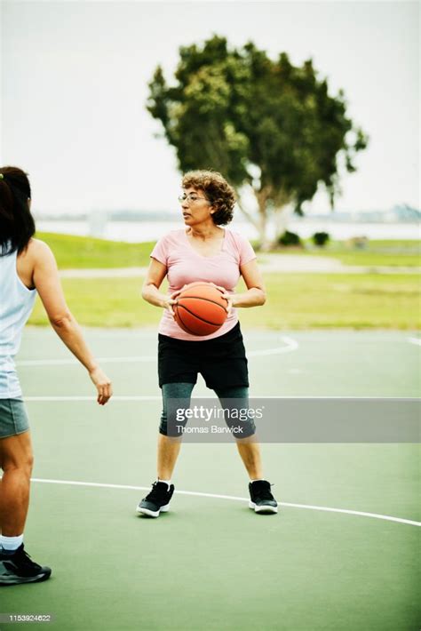 Mature Woman Looking To Make Pass During Basketball Game On Outdoor
