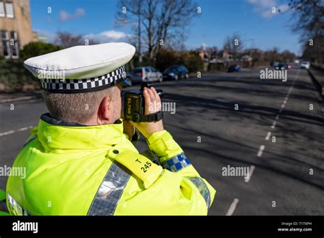 Traffic Police Officer Holding A Radar Speed Camera At An Urban Speed