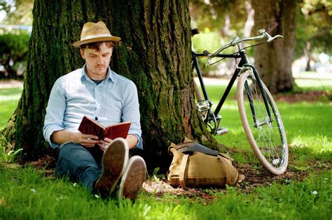Young Man Reading Book Under Tree Stock Photo Dissolve
