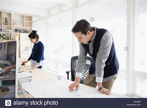 Male Architect Reviewing Blueprint In Office Stock Photo Alamy