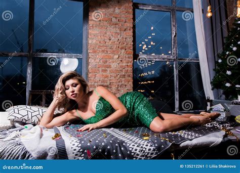 Beautiful Woman In Elegant Red Dress Lying On Modern Sofa Stock Image