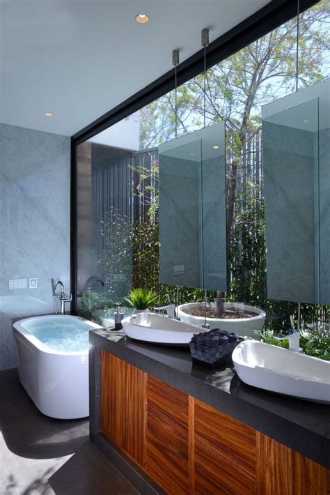A Bathroom With Two Sinks And A Bathtub Next To A Large Window That