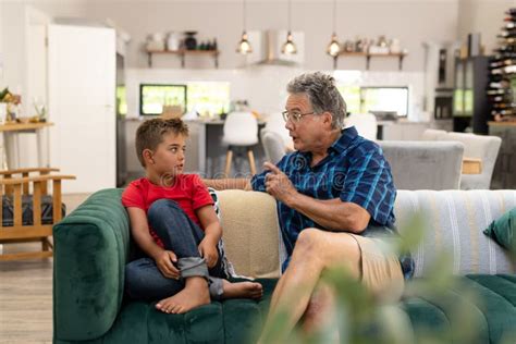 Caucasian Senior Man Gesturing And Talking With Cute Grandson While