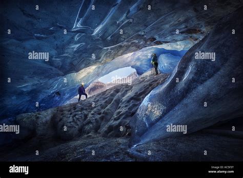 Explorers Couple Inside An Ice Cave During A Photography Expedition In