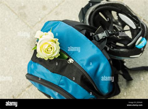 Blue Backpack With Buckled Bicycle Helmet And White Rose Adventure