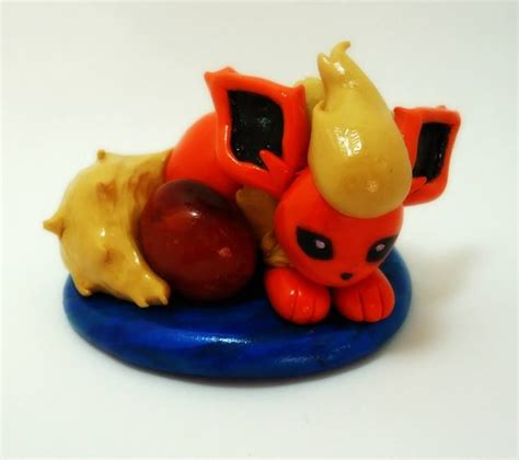 An Orange And Yellow Figurine Laying On Top Of A Blue Object