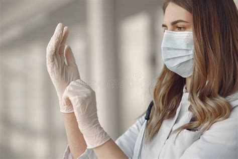 Woman In A Mask And Uniform Puts On Gloves Stock Image Image Of