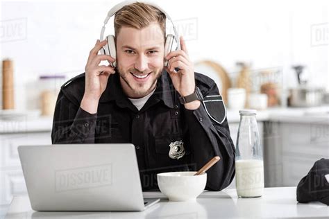 Smiling Police Officer Having Breakfast And Listening To Music With