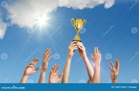 Winning Team Is Holding Trophy In Hands Many Hands Against Blue Sky