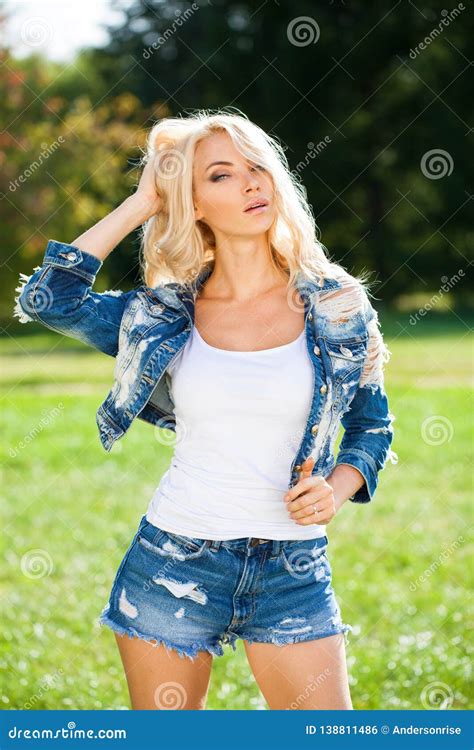 Beautiful Blonde Woman Dressed In A Denim Jacket And Shorts Stock Photo Image Of Attractive
