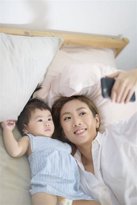 Asian Mother And Her Baby Daughter Are Making Selfie Or Video Call To
