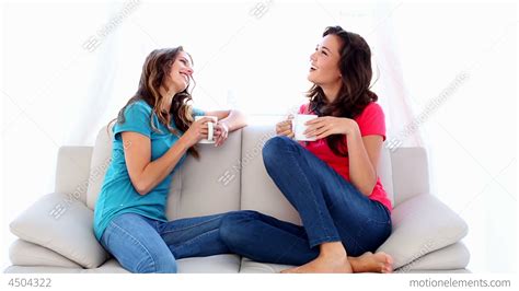 Lovely Chatting Women Sitting On Couch Holding Mug Stock Video Footage