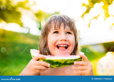 Cute Little Girl Eating Watermelon In Sunny Summer Garden Stock Photo
