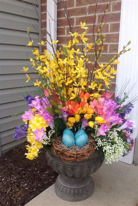 A Birds Nest Filled With Flowers And Two Blue Eggs Sitting On Top Of It