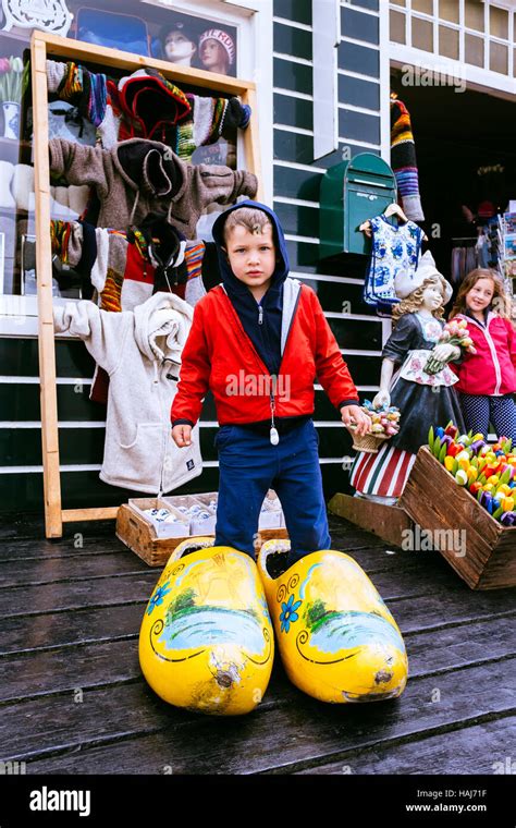 Little Boy Posing In Typical Huge Dutch Wooden Clogs Front Of A