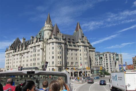 a group of people riding on the back of a bus in front of a tall building