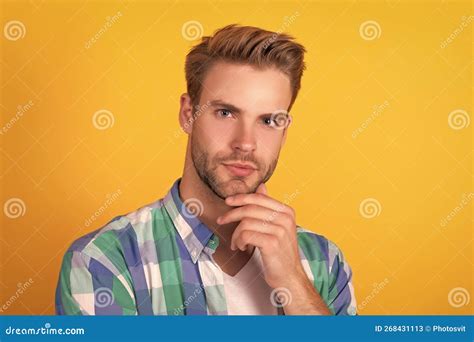 Handsome Unshaven Man Portrait Stroking Chin With Serious Look Yellow